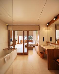 a bathroom with a sink and a living room at Riff Hikkaduwa in Hikkaduwa
