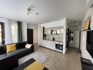 a living room with a couch and a kitchen at Zamardiresort in Zamárdi