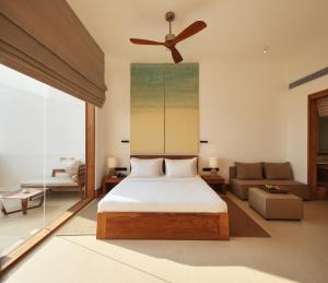 a bedroom with a bed and a ceiling fan at Riff Hikkaduwa in Hikkaduwa