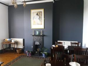 a dining room with a fireplace and a table at Wentvale in Knottingly