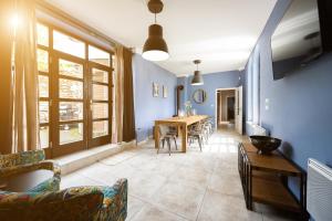 sala de estar con paredes azules, mesa y sillas en Penzion Pod hrádkem, en Mikulov
