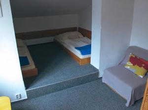 a small room with a bed and a couch at Chata Jamy in Vysoke Tatry - Tatranska Lomnica.