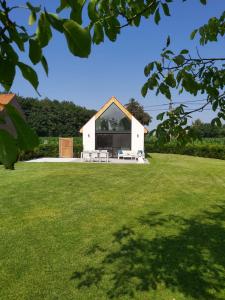 een wit huis met een groot grasveld bij Vakantiewoning Hélence in Merendree