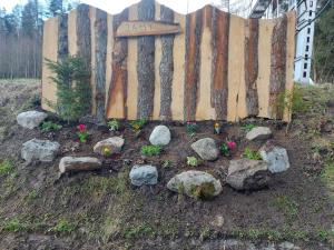 a garden with flowers and rocks next to a wooden fence at Chata Jamy in Vysoke Tatry - Tatranska Lomnica.