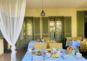 una sala da pranzo con due tavoli e piatti di Villa Oliva Boutique Rooms & Spa Zamárdi a Zamárdi