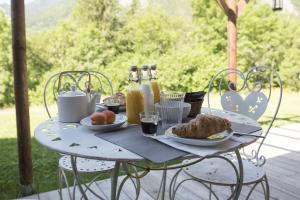 a table with breakfast foods and drinks on it at Chalet SALOON avec SPA privatif in Le Biot