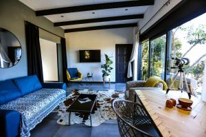 ein Wohnzimmer mit einem blauen Sofa und einem Tisch in der Unterkunft Hadada Self Catering Studio in Haga-Haga