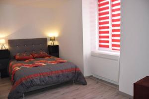 - une chambre avec un lit et une fenêtre avec volets rouges dans l'établissement A 20 mn du Puy du Fou coquette et fonctionellle, à Mauléon
