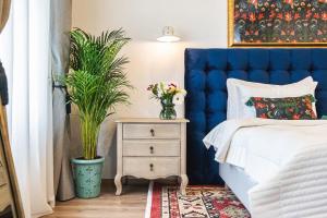 a bedroom with a blue headboard and a nightstand with a plant at NIKOLAS HAUS with Free Parking in Braşov