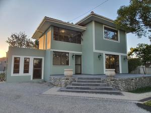 a green house with stairs in front of it at Coral Tree Boutique Guesthouse in East London