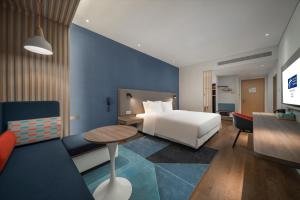 YixingにあるHoliday Inn Express Yixing, an IHG Hotelのベッドとテーブルが備わるホテルルームです。