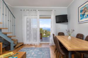 jadalnia ze stołem i przesuwnymi szklanymi drzwiami w obiekcie AnD Charming apartment in Vantačići w mieście Malinska