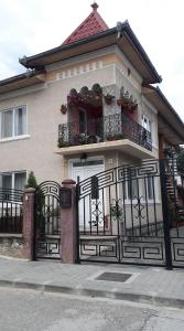 ein Haus mit einem Tor und einem Balkon mit Blumen in der Unterkunft Casa Corina in Călimăneşti