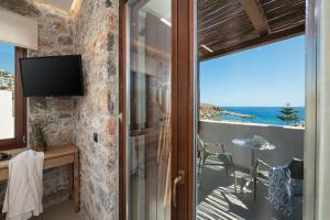a room with a balcony with a view of the ocean at The Authentic Village Boutique Hotel in Hora Sfakion