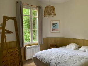 1 dormitorio con cama y ventana en Villa Marguerite, en Lège-Cap-Ferret