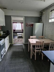 cocina con mesa, sillas y nevera en Hostelli Karvia en Karvia