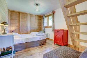 een kleine slaapkamer met een bed en een rode kast bij ALTAKA 3 in Morzine