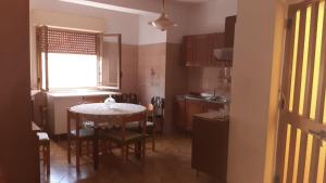 a kitchen and dining room with a table and chairs at Lontano dal caos a due passi dal mare in Condrò