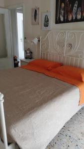 een slaapkamer met een groot bed en een oranje deken bij Il centro di Napoli in Napels