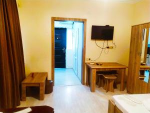 a room with a television and a table and a desk at Guesthouse Family in Tbilisi City