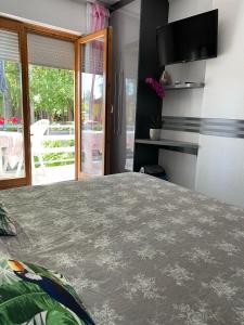 a bedroom with a bed and a sliding glass door at Pearl Home Siofok in Siófok