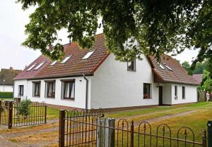 a white house with a red roof at schoene Ferienwohnung mit Terrasse in Ralswiek