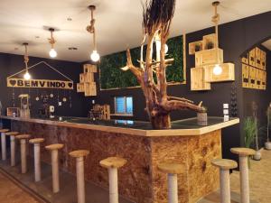 a bar in a restaurant with a tree on the counter at Atlantic Nature Beach House in Poço da Cruz