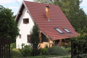 une maison blanche avec un toit rouge et des fenêtres dans l'établissement ČAROBNA ŠUMA ***(magic forest), à Karlovac