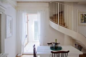 a dining room with a table and a staircase at Casa Vicolo Castello in Ravenna