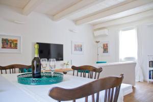 a dining room with a table with a bottle of wine at Casa Vicolo Castello in Ravenna