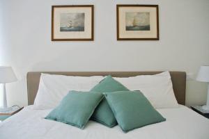 two green pillows sitting on top of a bed at Casa Vicolo Castello in Ravenna