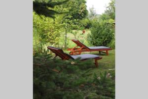two picnic tables and a bench in a yard at ČAROBNA ŠUMA ***(magic forest) in Karlovac