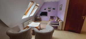 salon z fioletowymi ścianami, stołem i krzesłami w obiekcie Leonia Apartments w Zakopanem