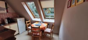 małą kuchnię ze stołem i krzesłami oraz oknem w obiekcie Leonia Apartments w Zakopanem