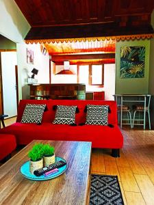 a living room with a red couch and a table at La Caz'Anna in Cilaos