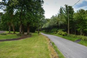 una strada vuota con alberi su entrambi i lati di The Cedar Country Hotel a Bellway