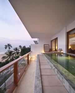 a house with a swimming pool and a balcony at Riff Hikkaduwa in Hikkaduwa