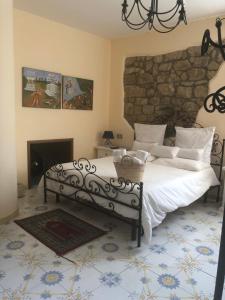 a bedroom with a bed and a stone wall at San Noto Antica Residenza di Caccia in Ficarra