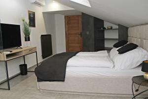 a bedroom with a bed and a desk with a television at Player's Pool&Rooms in Vonyarcvashegy
