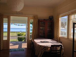a dining room with a table and a view of the ocean at 35 Flinders Ave in Dunwich