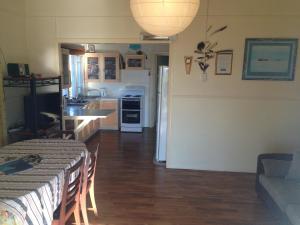 a kitchen and a living room with a table and chairs at 35 Flinders Ave in Dunwich