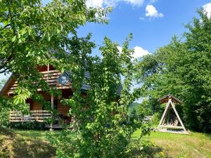 a log cabin with a gazebo in front of it at CHATA POD CZEŚNIĄ in Brzozowiec