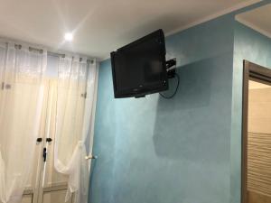 telewizor z płaskim ekranem na ścianie pokoju w obiekcie B&B Pirro Malena w mieście Casa Toscano