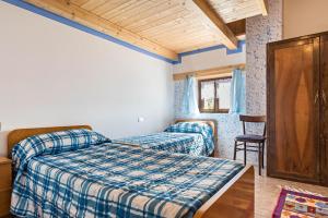 Un dormitorio con 2 camas y una silla. en Baita Località Cap, en Roncone