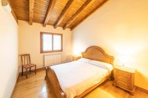 ein Schlafzimmer mit einem Bett und einem Stuhl in der Unterkunft Casa rural Gibelea txiki in Viscarret-Guerendiáin