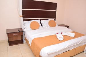 a bedroom with a large bed with two towels on it at Nairobi Glory Palace Hotel Ltd in Nairobi