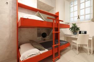 czerwone łóżko piętrowe w pokoju z biurkiem w obiekcie Grand Tour Rome Apartment - Liberty Collection w Rzymie