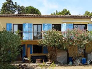 una casa con ventanas con persianas azules y árboles en Bed & Diner Les Terrasses de La Palme, en Lapalme