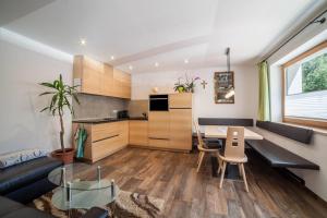 a kitchen and living room with a table and a couch at Ferienwohnung Haus Fliri in Melago