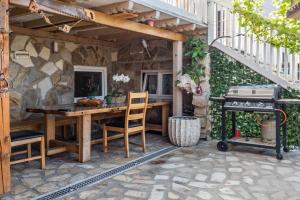 eine Außenterrasse mit einem Holztisch und einem Grill in der Unterkunft Ferienwohnung Insel Reichenau in Rheinstraße